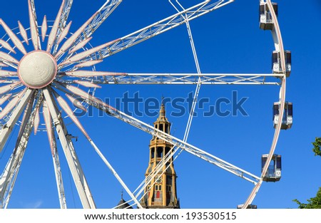 Ferris wheel and the \'Aa kerk\' in Groningen on a beautiful day at the fair ground.