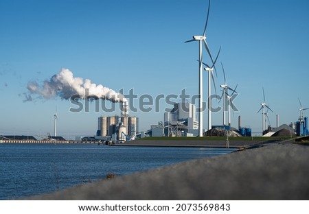 Fossil fuel (coal) power station and wind turbines in the Eemshaven generating power. Energy transition concept. Stockfoto © 