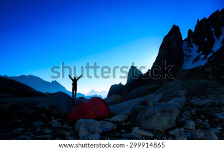 Silhouette of a hiker enjoying a new dawn in the mountains. Sports en outdoor concept.