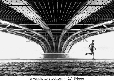 Man running under the Pont de l' Universite bridge in Lyon on a warm, spring day. Imagine de stoc © 