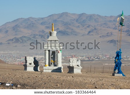 Buddhist stupa in the mountains of Mongolia on the background of the settlement