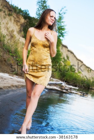 beautiful girl in wet dress goes on shore