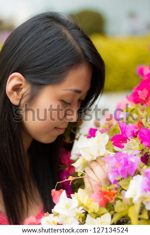 Cute Thai girl scent a pink colorful Kertas. She loves flowers.