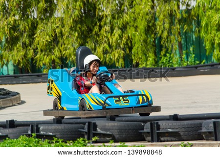 BANGKOK, THAILAND - 10 MAY 2013: unidentified Thai girl is driving Go-kart at the racing court on May 10, 2013. Go-kart is one of the favorite extreme sport for Thai teens.