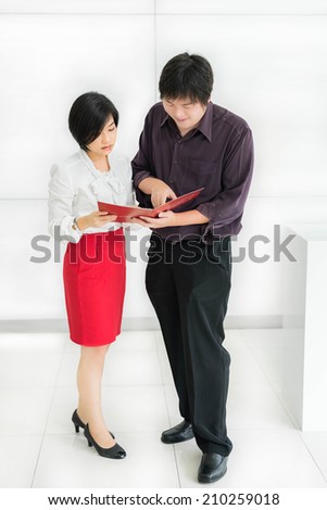 Thai (Asian) boss is ordering a task for his cute secretary in the office