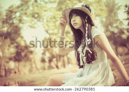A cute Asian Thai girl is looking in the sky with hope in vintage color with soft focus