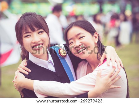 Thai girl is hugging her friend who graduated a master degree in vintage color