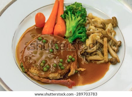 Filet Mignon steak with gravy sauce and carrot broccoli mushroom side-dish on dish. It\'s a international French cuisine food