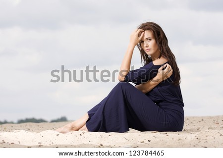 Sexy brunette woman posing in violet dress.
