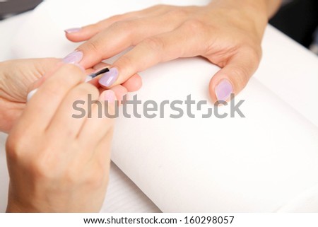 Manicure - Beautiful manicured woman\'s nails with violet nail polish on soft white towel.