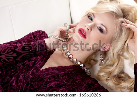 Beautiful and sexy young adult blonde woman wearing elegance fashion table dress in white sofa