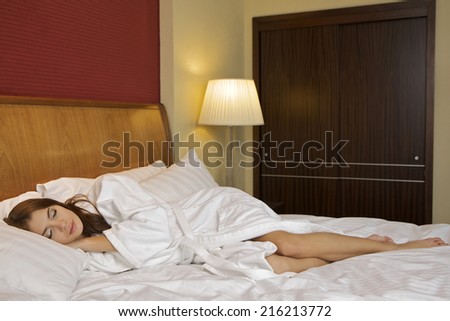 Young adult attractive and sensuality beautiful brunette woman in white bathrobe on the bed