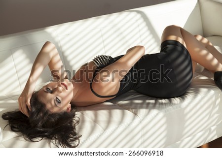 Beautiful attractive sensuality and sexy young adult pretty brunette woman wearing elegance fashionable lingerie dress in white sofa