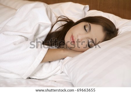 Closeup portrait of a cute young beautyful brunette woman sleeping on the bed
