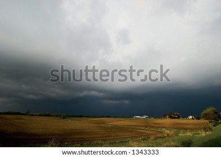 Farm and field with impending tunderstorm in background - copy space