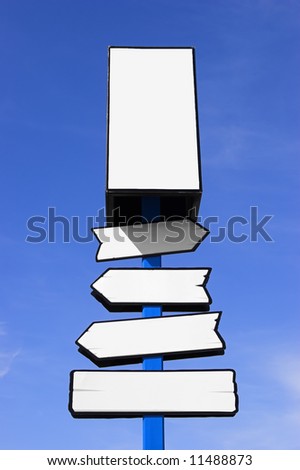 White directional signpost against a blue sky. Place your signs/logos.