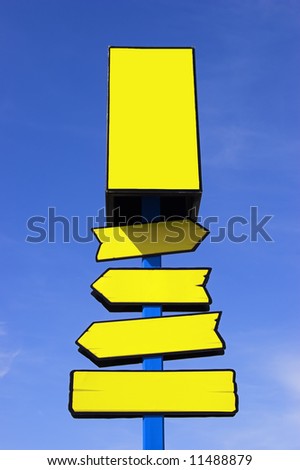 Yellow directional signpost against a blue sky. Place your signs/logos.