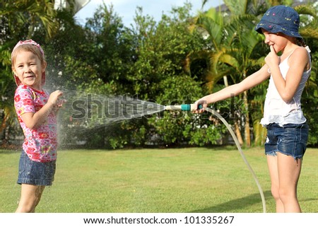 A girl pours water from a hose at my sister