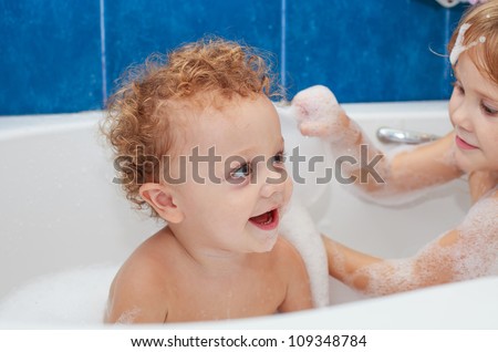 Cute one year old boy taking a relaxing bath with foam.  The symbol of purity and hygiene education.