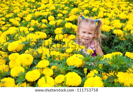 one happy little girl on a glade of yellow flowers