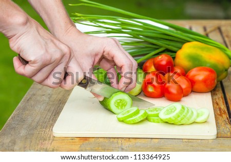 sliced cucumber. Woman  cut cucumber  knife