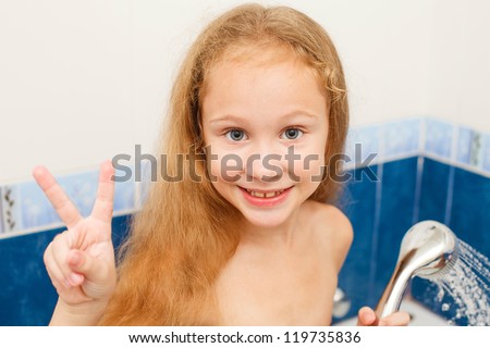 Cute eight year old girl taking a relaxing bath with foam. The symbol of purity and hygiene education.