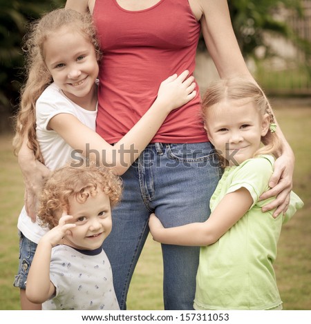 three happy kid hugging his mother