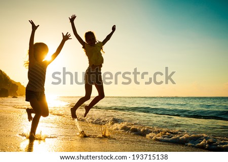 happy kids playing on beach at the sunrise time