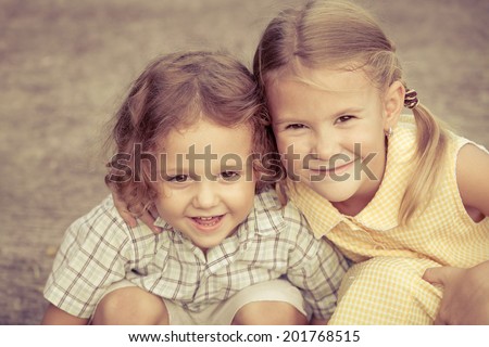 Happy kids sitting on the road. Concept Brother And Sister Together Forever