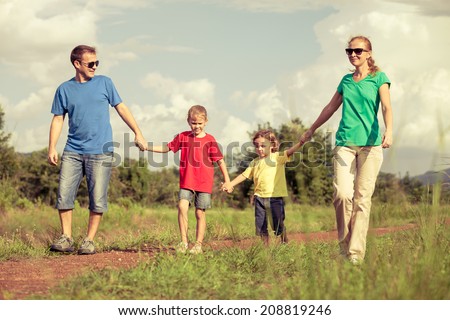 Happy family walking on the road at the day time. Concept of friendly family.
