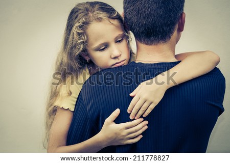 portrait of one sad daughter hugging his father