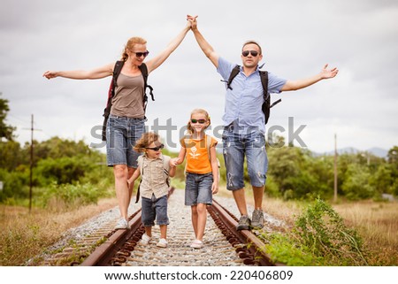 Happy family walking on the railway at the day time. Concept of friendly family.