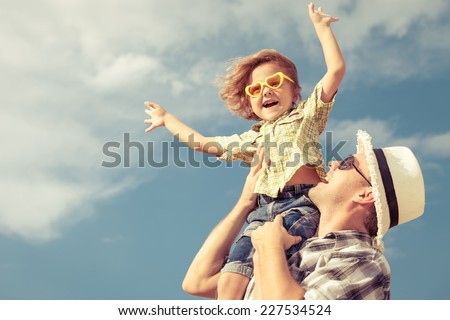Dad and son playing near a house at the day time