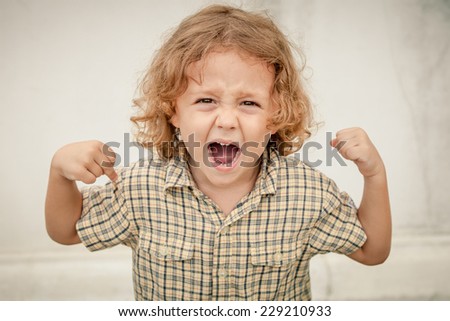 Portrait of a screaming little boy at the day time
