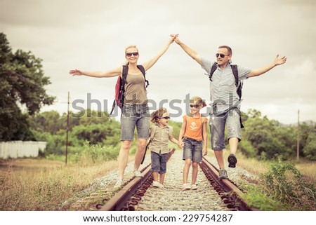 Happy family walking on the railway at the day time. Concept of friendly family.