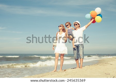 Happy family playing  with balloons on the beach at the day time. Concept of friendly family.