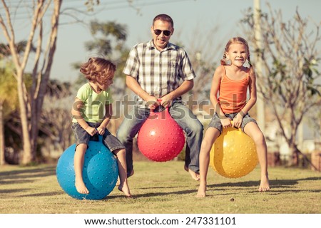 Dad and children playing on the lawn in front of house at the day time
