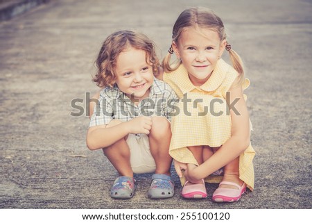 Happy kids sitting on the road. Concept Brother And Sister Together Forever