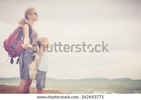 Mother and daughter standing  on the beach at the day time. Concept of friendly family.