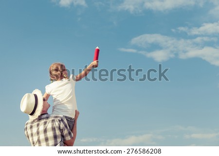 Dad and daughter in sunglasses playing near a house at the day time. Concept of friendly family.