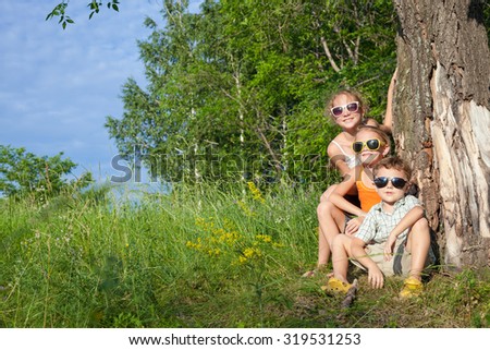Three happy children  playing in the park at the day time. Concept Brother And Sister Together Forever