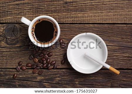 Coffee, ashtray and cigarette on vintage wooden background. Top view