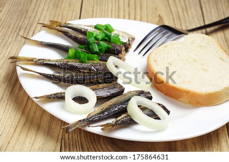 Fresh smoked sprats and white bread on table. Selective focus