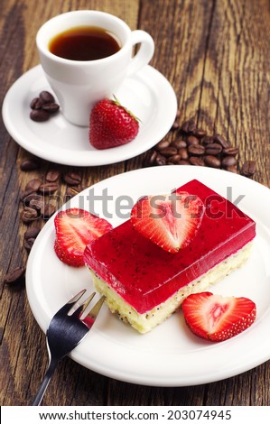 Cup of coffee and strawberry cake with poppy on wooden table
