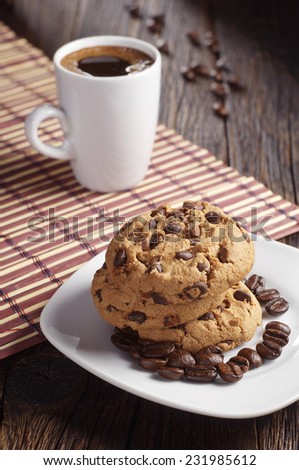 Plate with chocolate cookies and coffee cup on coffee on bamboo napkin