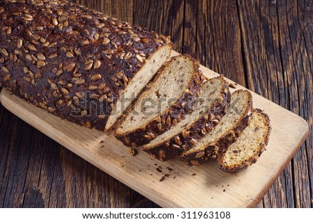 Sliced bread with seeds on cutting board