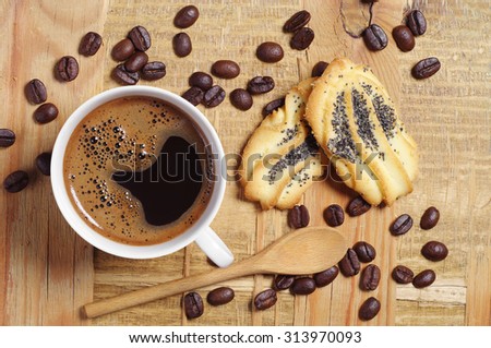 Cup of hot coffee and cookies with poppy on rustic wooden table, top view