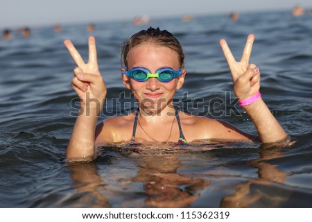 Girl hands show victory gesture in the sea, Rhodes, Greece