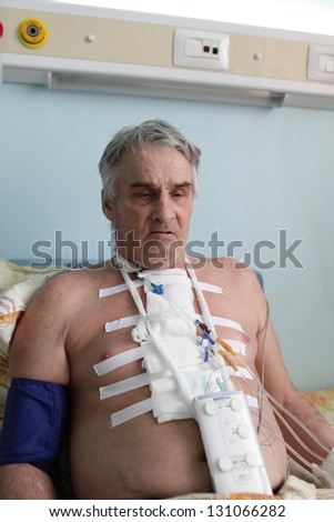 Man with pacemaker after heart surgery in a hospital ward