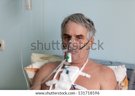 Person with oxygen mask in a hospital ward